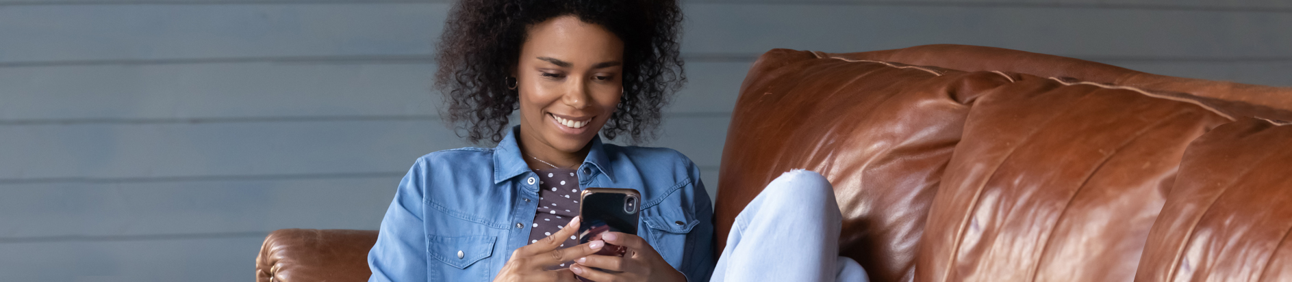 Woman sitting on couch using phone